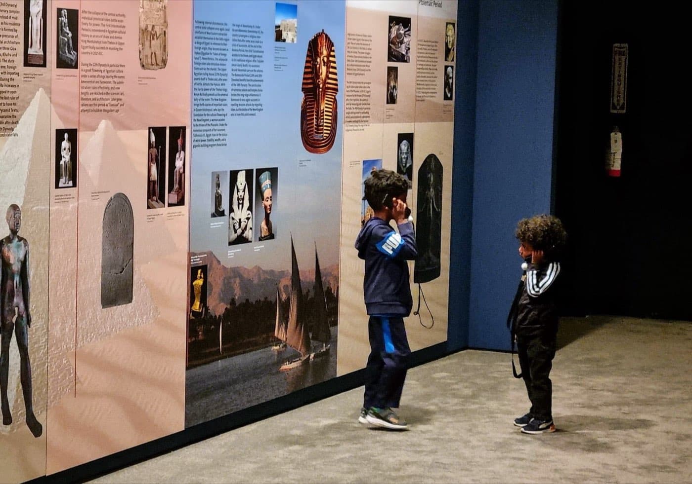 Visitors using audio guides inside the Tutankhamun exhibition